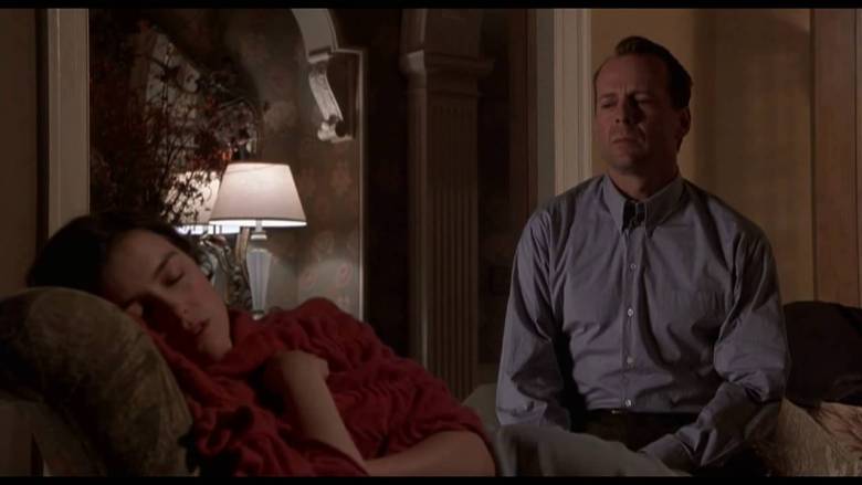 Scene in The Sixth Sense. Malcolm is sitting and watching Anna sleep. Anna is holding a red blanket.